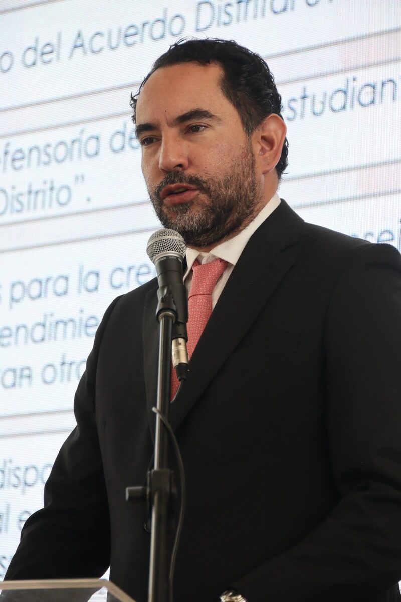 Rolando González habla en un atril durante la presentación de un acuerdo distrital