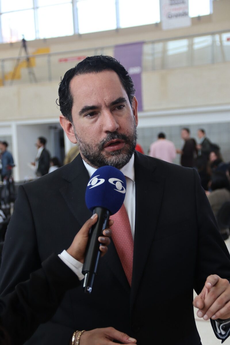 Rolando González responde preguntas a un periodista con micrófono